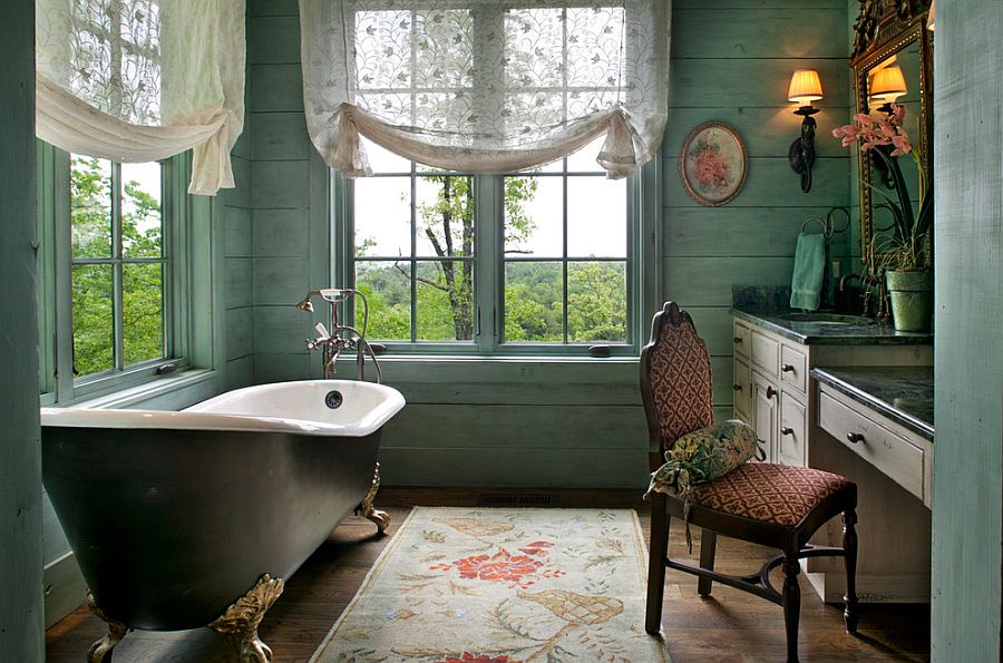 Serene Victorian bathroom with light green walls, unique rug and vintage bathtub