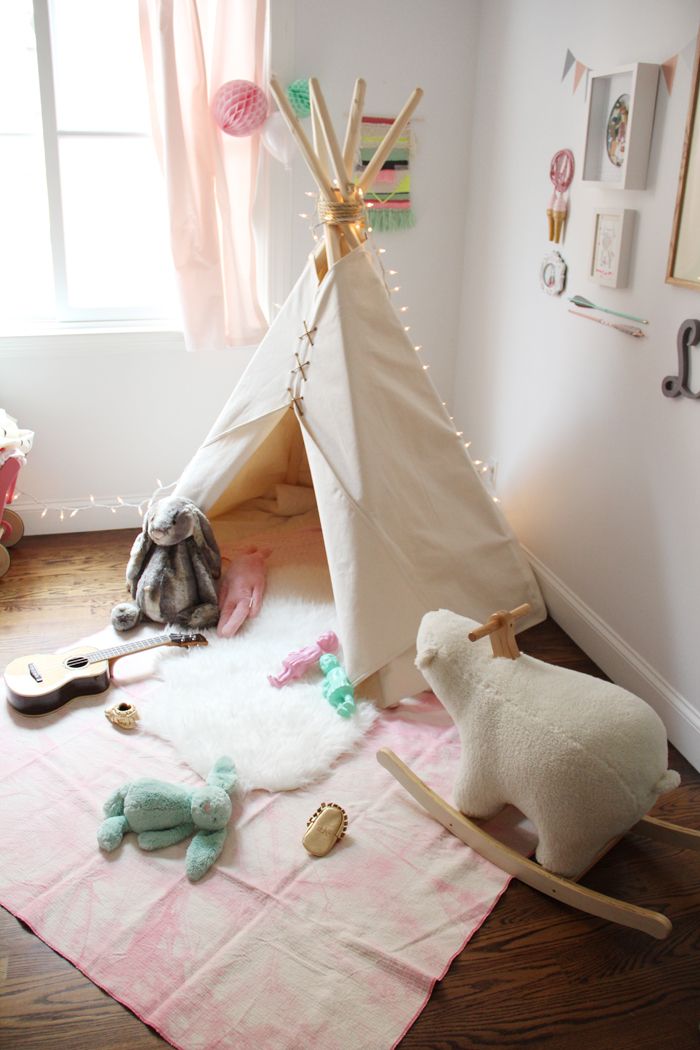 Simple white teepee with lots of toys nearby to play with