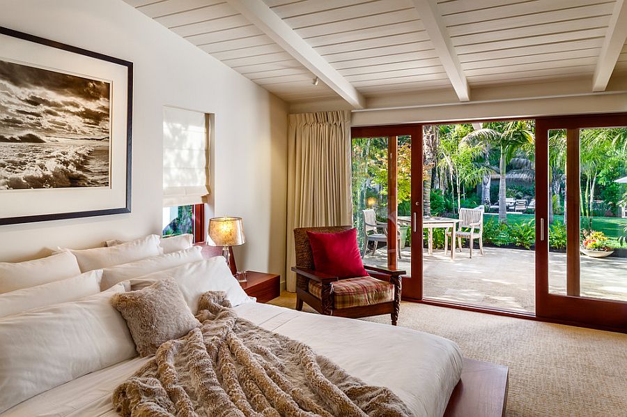 Sliding glass doors connect the bedroom with the greenery outside