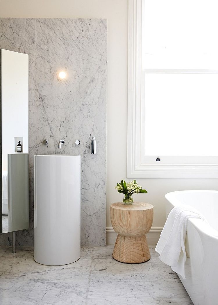 Small side table with woodsy beauty adds textural contrast to the contemporary bathroom