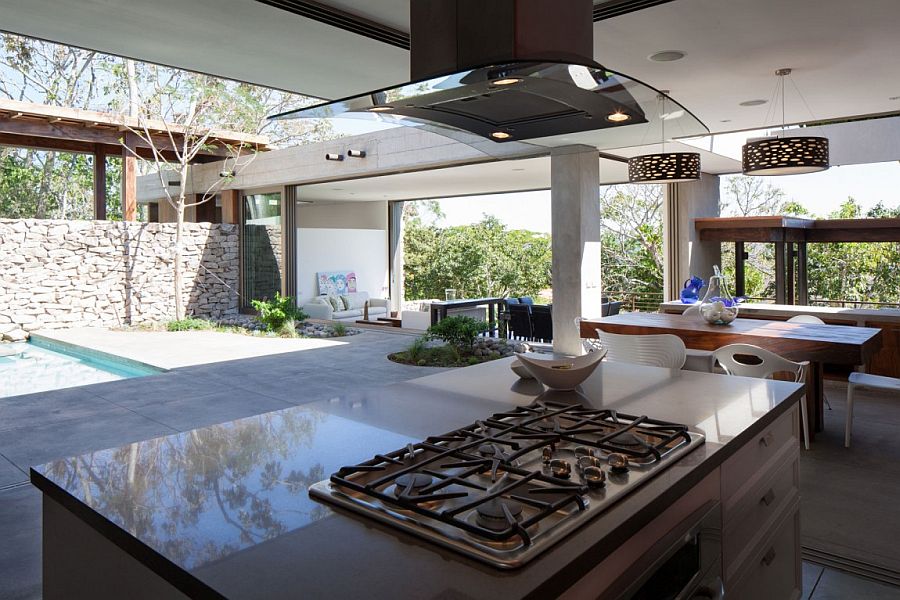 Smart outdoor kitchen and dining next to the pool deck