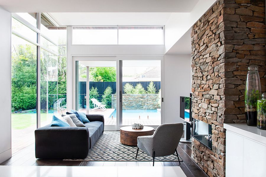 Stone wall fireplace becomes a part of both the living area and the kitchen visually