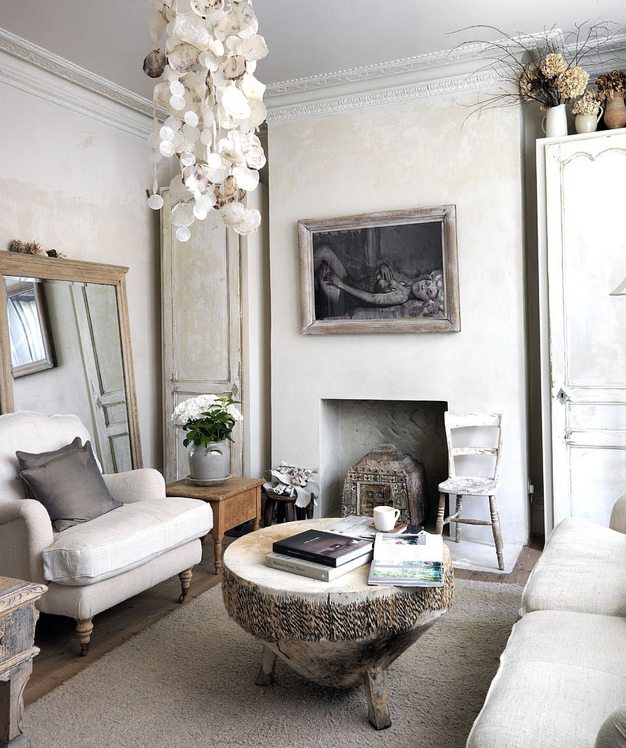 Tree trunk coffee and antique mirror epitomize the shabby chic style of the room