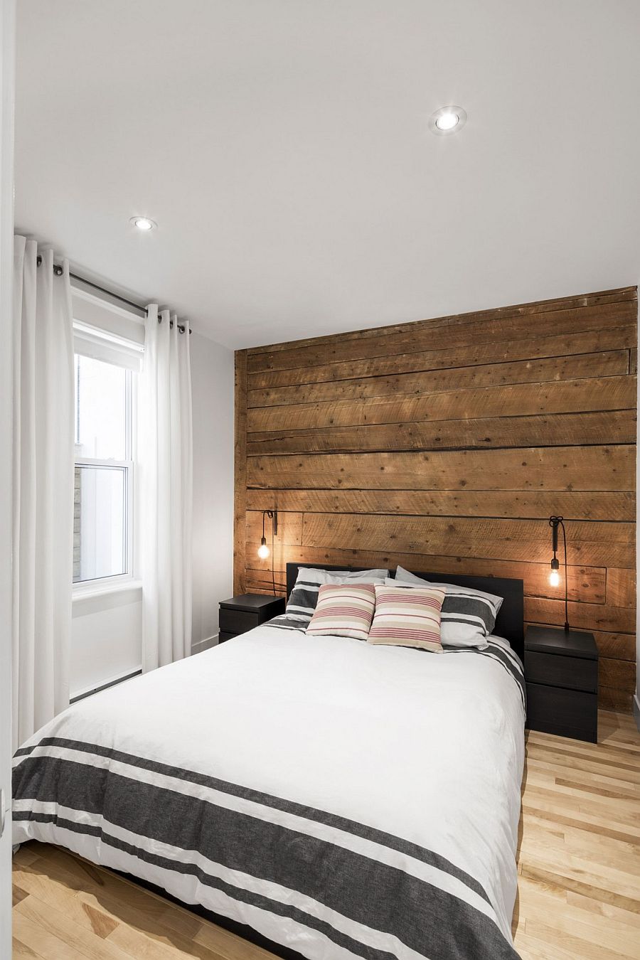 Wall of original wooden boards creates a lovely ambiance in the bedroom