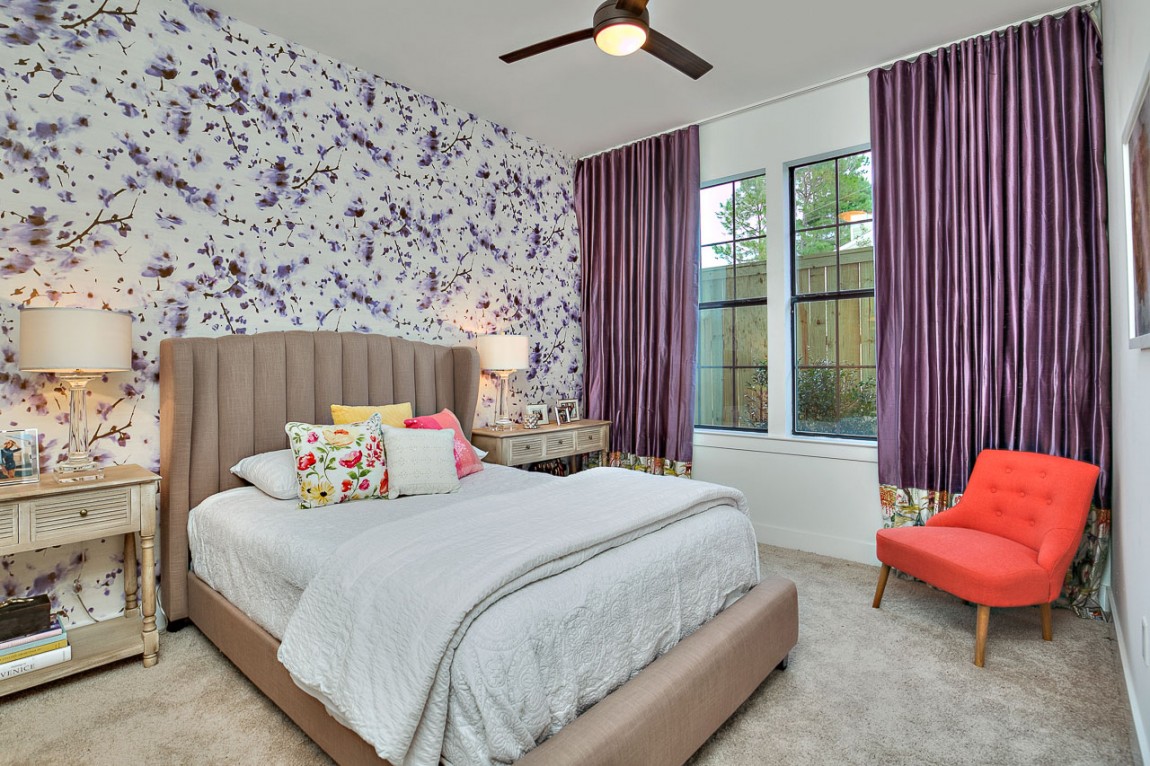 Wallpaper and drapes bring purple to the charming bedroom