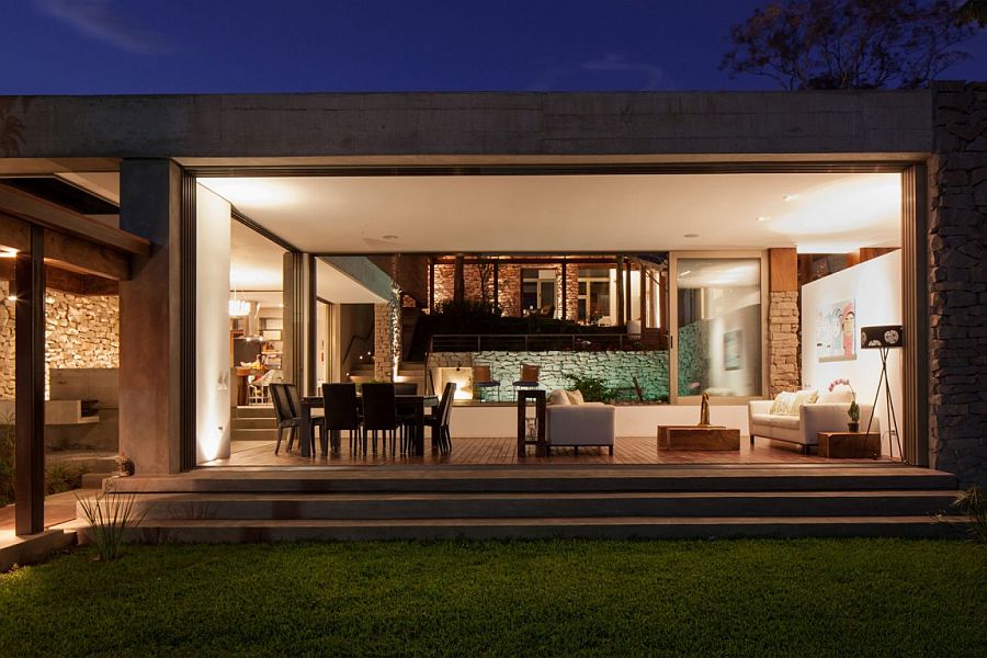 Warm lighting lets the indoors shine through after sunset at the family residence in El Salvador