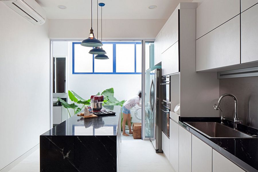 White and bright modern kitchen with dark central island and worktops in stone