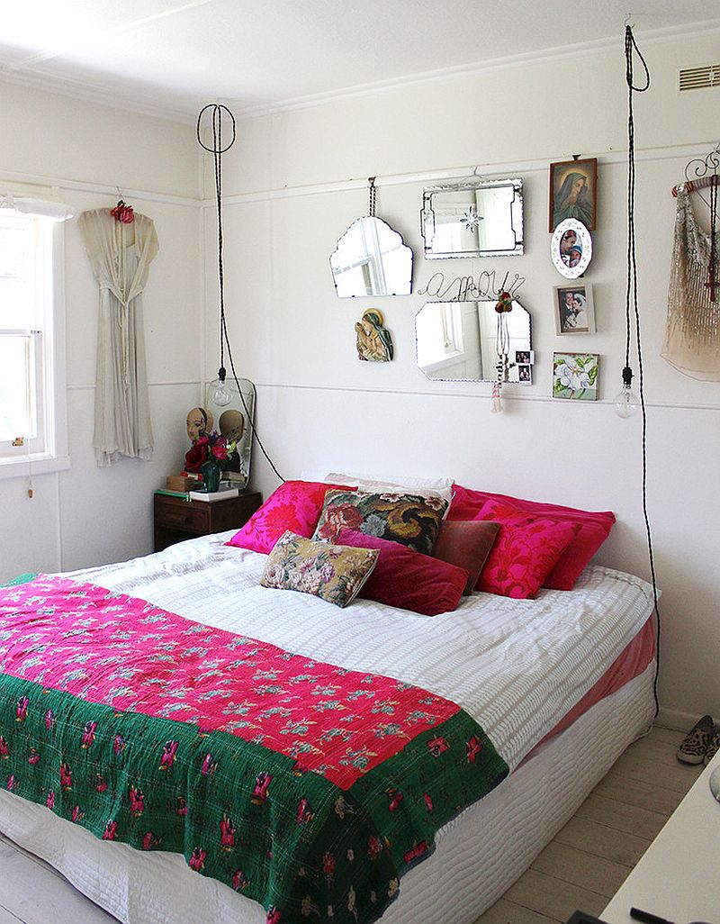 Wire pendant lights, bright accent pillows and colourful bedding shape the shabby chic bedroom