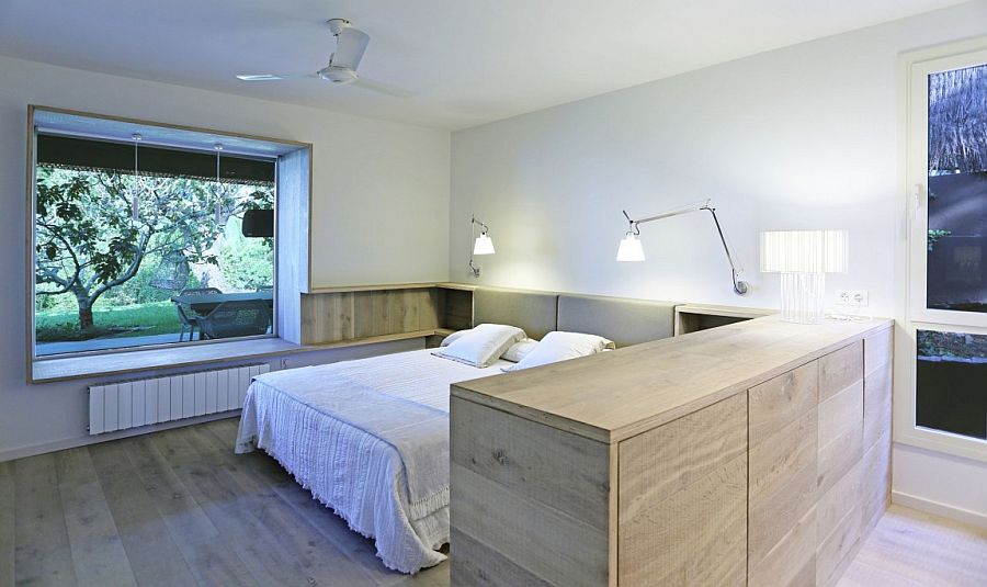 Wooden cabinet and headboard shelves seem like an extension of the flooring