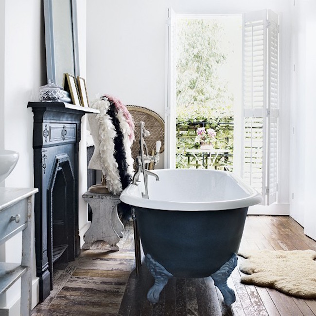 A fireplace and matching clawfoot tub in a bathroom with a balcony