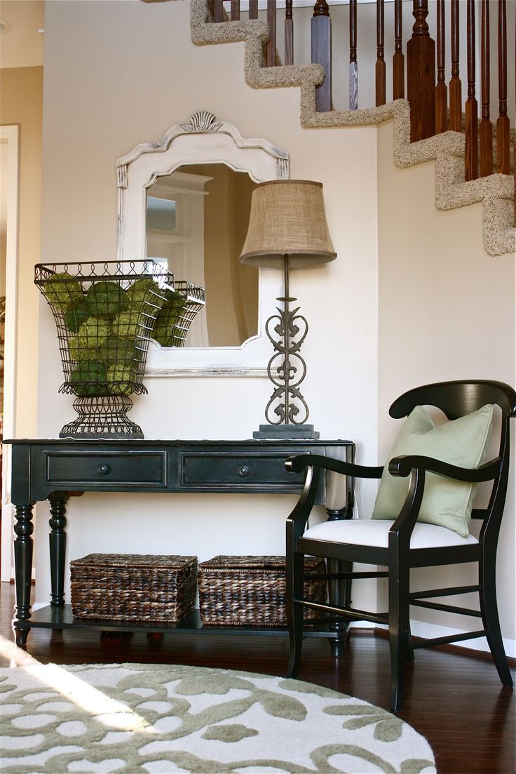 An elegant white and weathered wood mirror hung near the stairs in an entryway