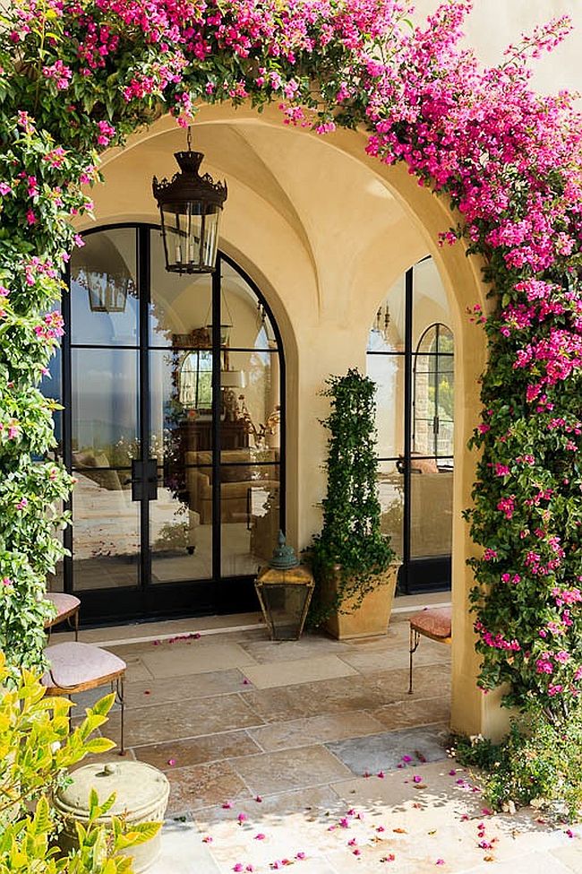 Arched entryway covered in greenery epitomizes the Mediterranean style entry