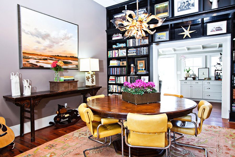 Black bookshelves separate the eclectic dining room from the kitchen