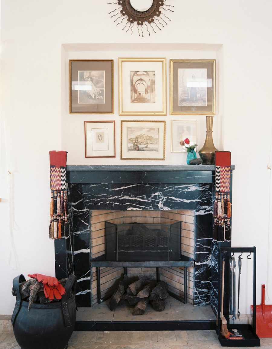 Black marble fireplace under a wall art display