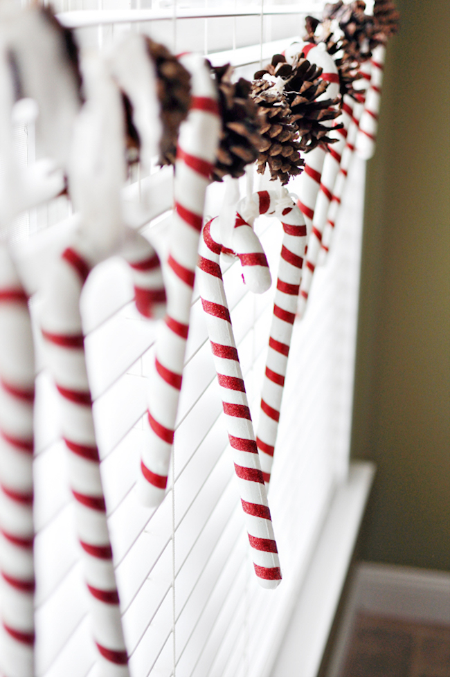 Candy canes and pinecones hung in a window
