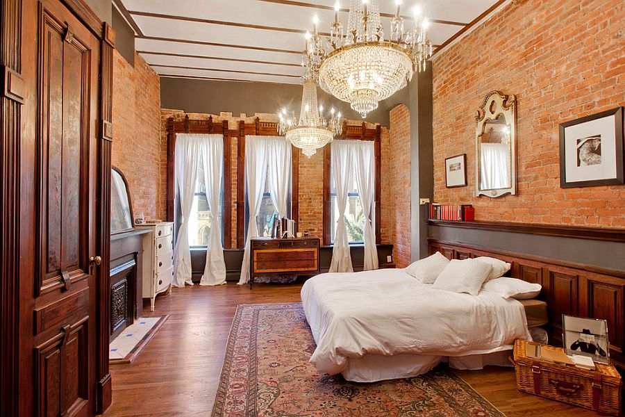 Chandeliers and brick walls give the bedroom a classy appeal [Design: GooseNest Interior Design]