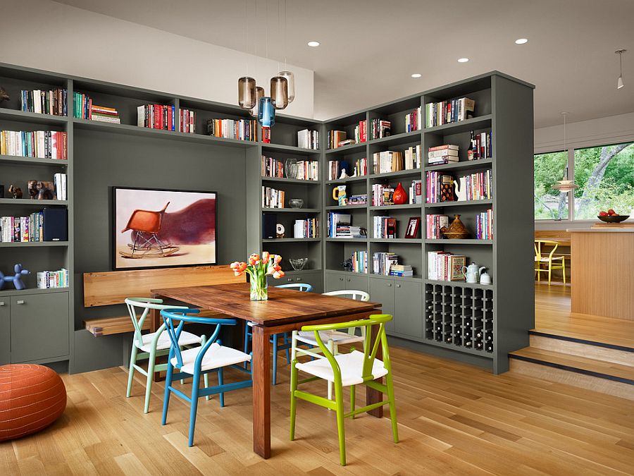 Colorful collection of wishbone chairs and gorgeous gray bookshelves add to the charm of this dining room [Design: Furman + Keil Architects]