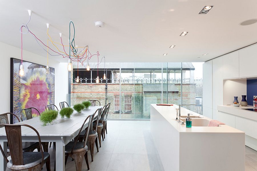 Colorful wires and Edison bulbs create a fascinating lighting fixture in the Scandinavian dining room