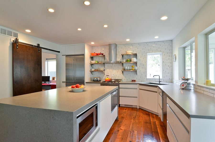 Contemporary kitchen uses the sliding barn door to bring a unique texture to the setting [Design: Refined LLC]