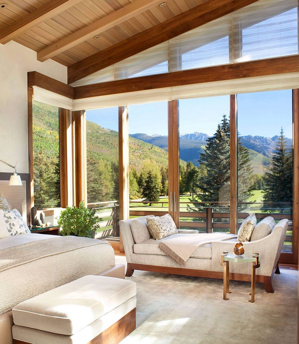 Corner windows of the bedroom with walnut trims open it up towards the mountain view outside