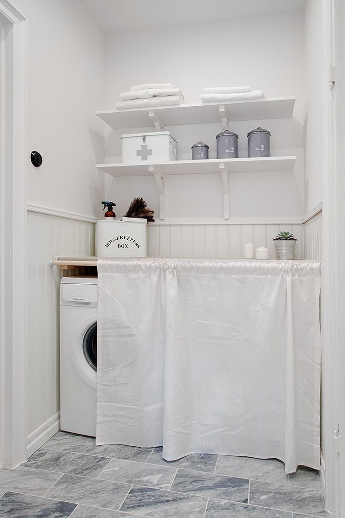 Crisp clean laundry room with a white sheet to hide washer and dryer