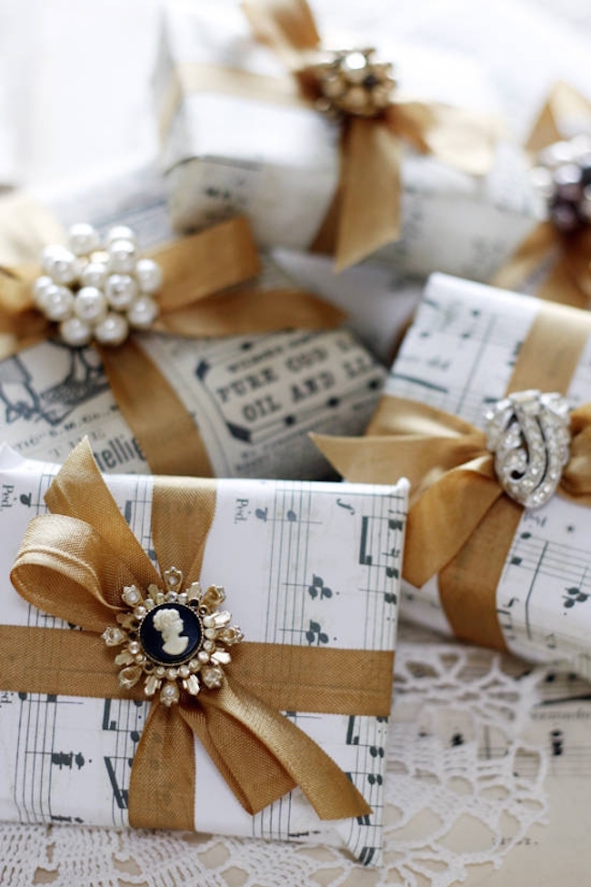 DIY wrapping paper using sheet music, gold ribbon, and jewelry pieces