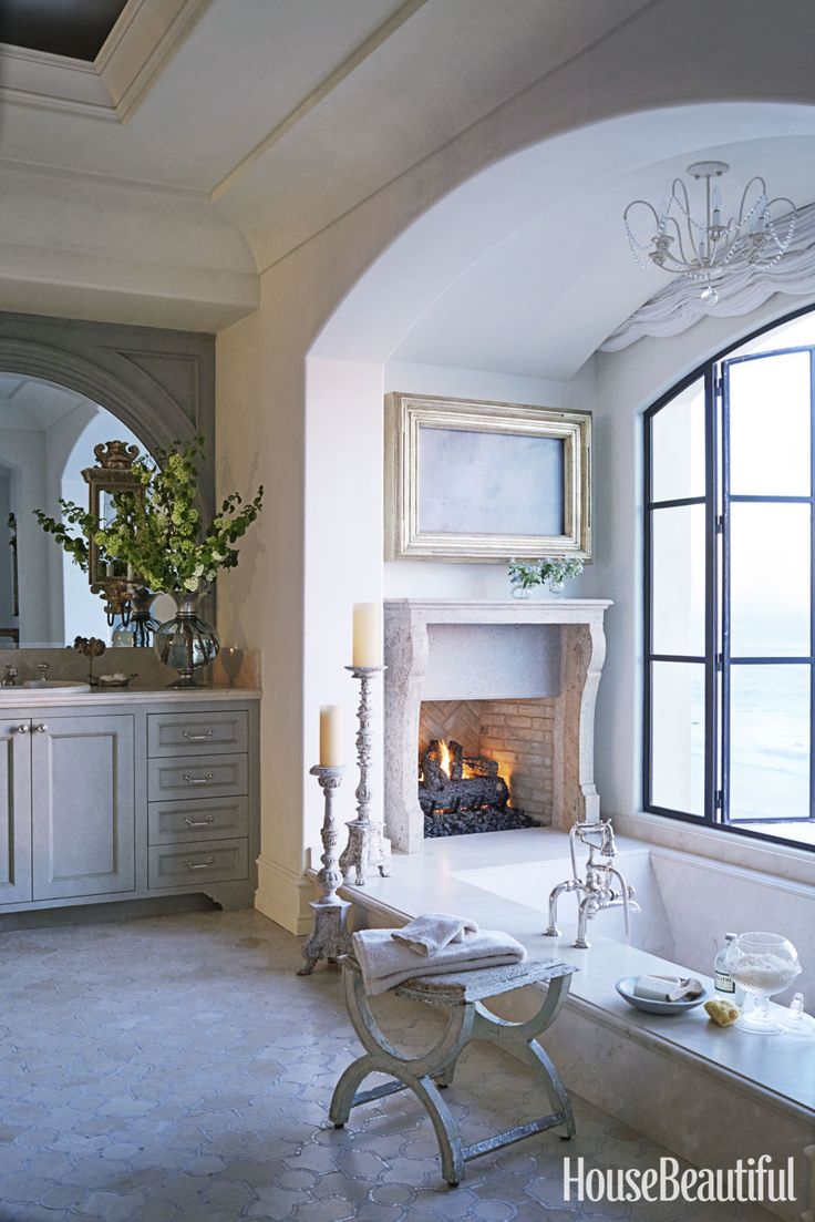 Deep luxurious bathtub with fireplace off to the side