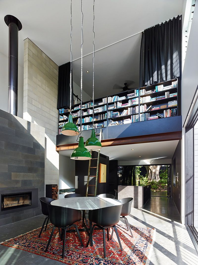 Double height dining room with a wall of books not for the faint of heart