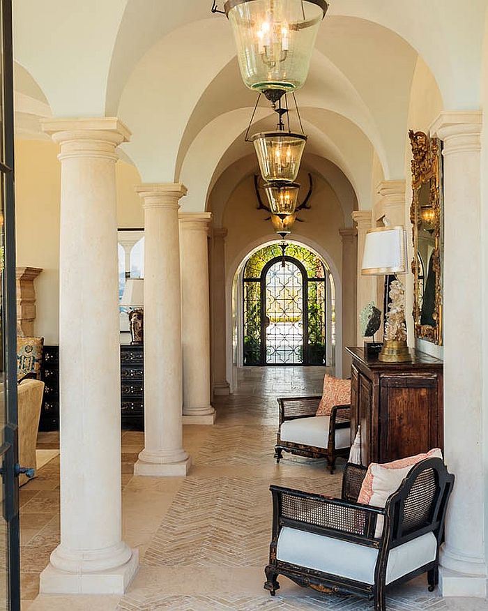 Dramatic hallway seems even more classical thanks to the lighting fixtures and antique mirror