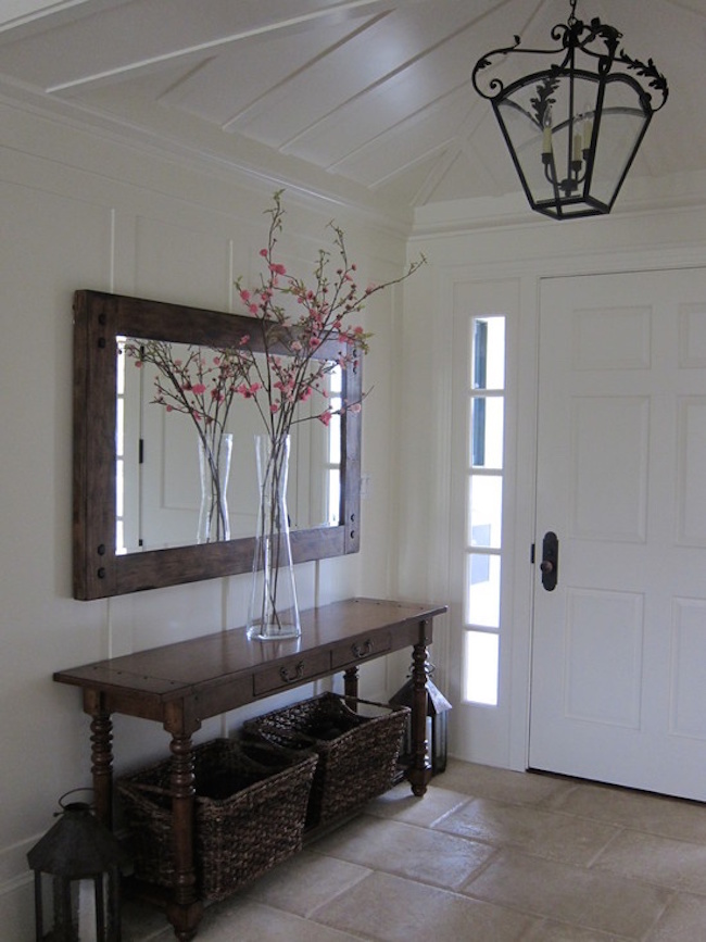 Entryway with a long dark table and matching mirror