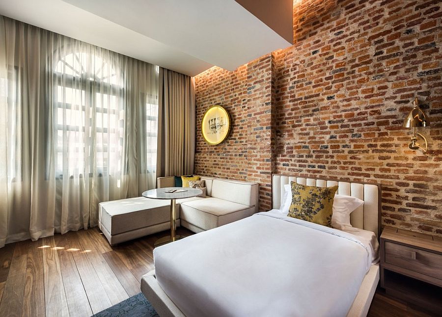 Exposed brick walls bring historic context to the refined, modern interiors of Loke Thyee Kee Residences