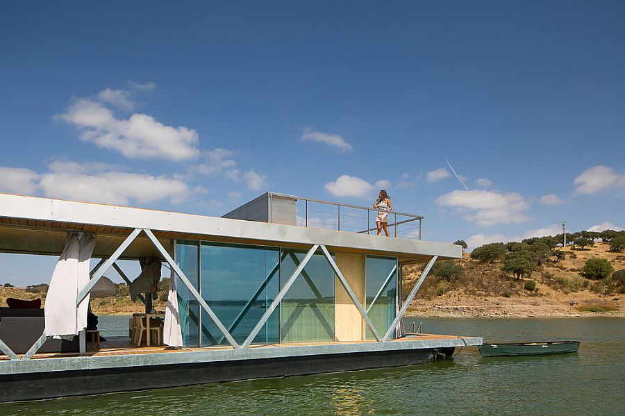 Floor-to-ceiling glazing surrounds the living area of the houseboat