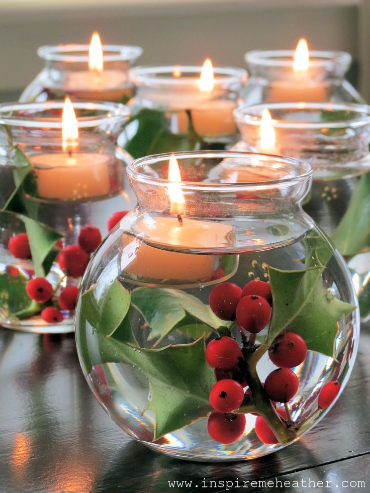 Glass bowls filled with water, holly, and floating candles