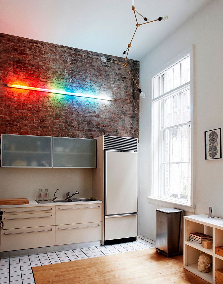 Interesting use of lighting highlights the exposed brick wall in the double height kitchen