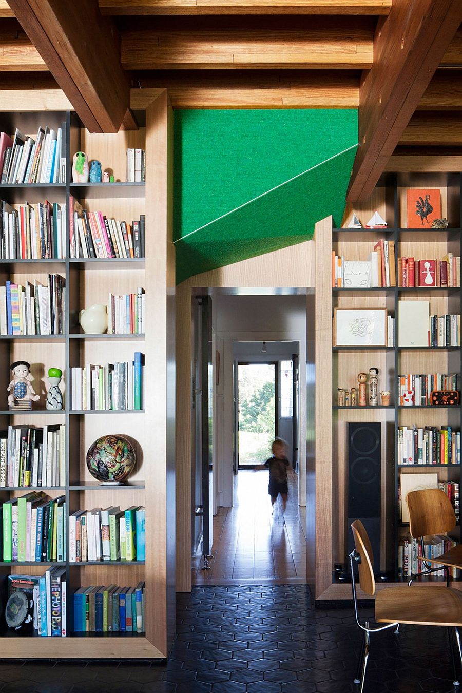 Large bookshelves and wooden walls separate spaces inside the Doll's House