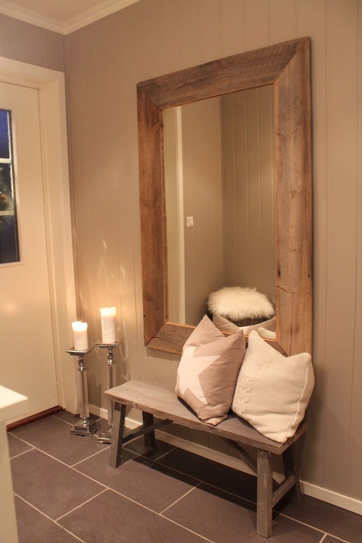 Large framed mirror hung above rustic wood bench