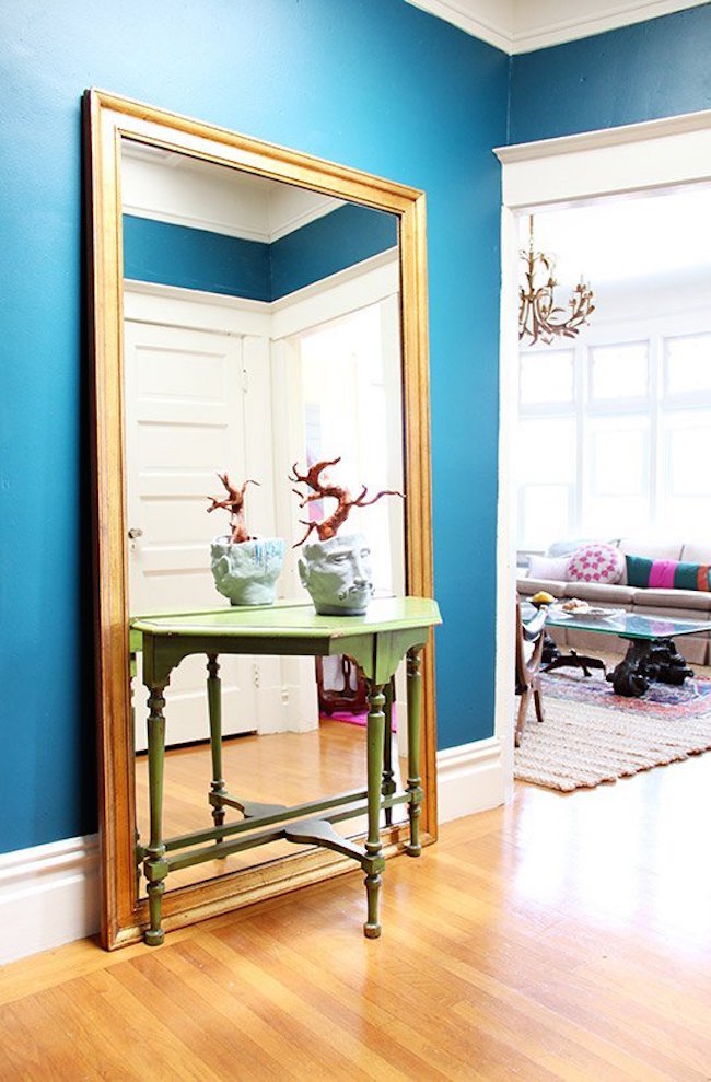 Large full-length mirror behind a small entryway table