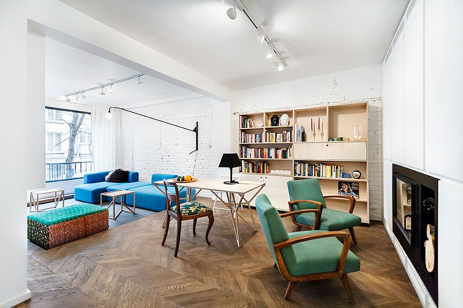 Living room of the space-savvy apartment with exposed brick wall and chevron flooring