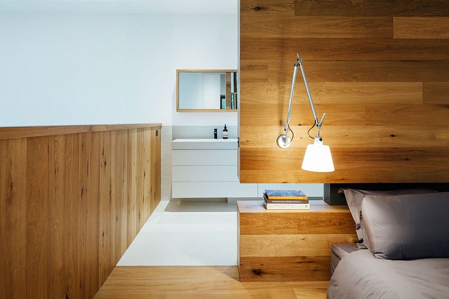 Master bedroom with custom wooden headboard wall and cool sconce lighting