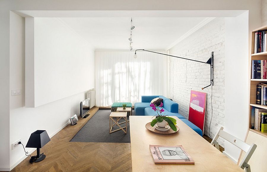 Modern eclectic living room with modular sofa, brick walls and a TV on the floor