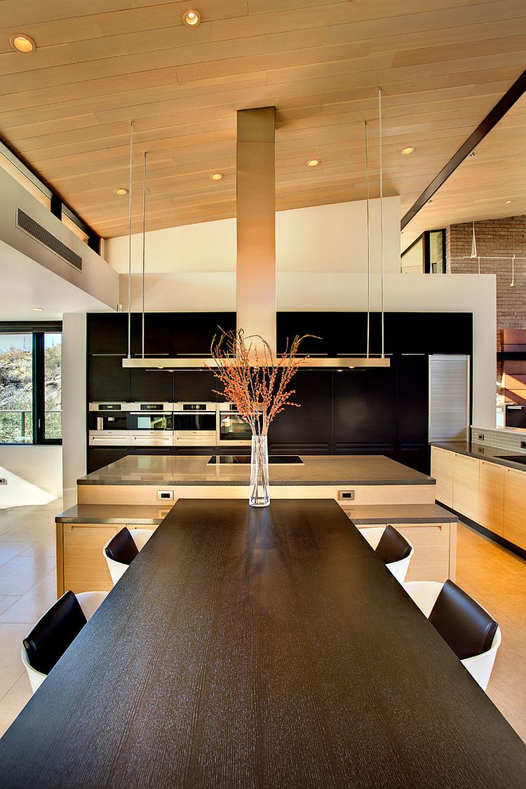 Modern kitchen and dining area with dark wall for cabinets and appliances