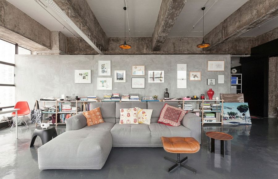 Open plan living area of industrial loft with plish gray couch