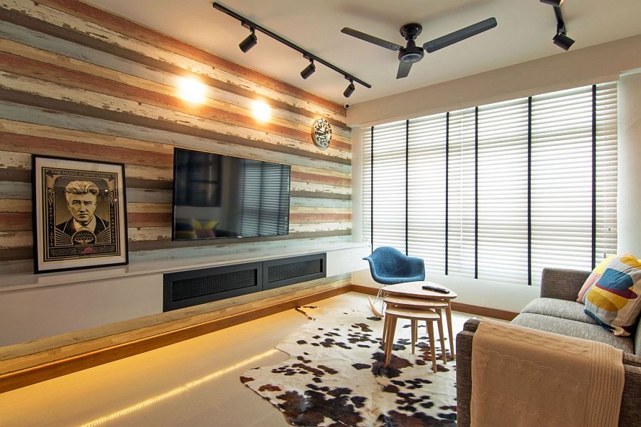 Recliamed wooden wall and unassuming decor give the living space a cozy, contemporary ambiance