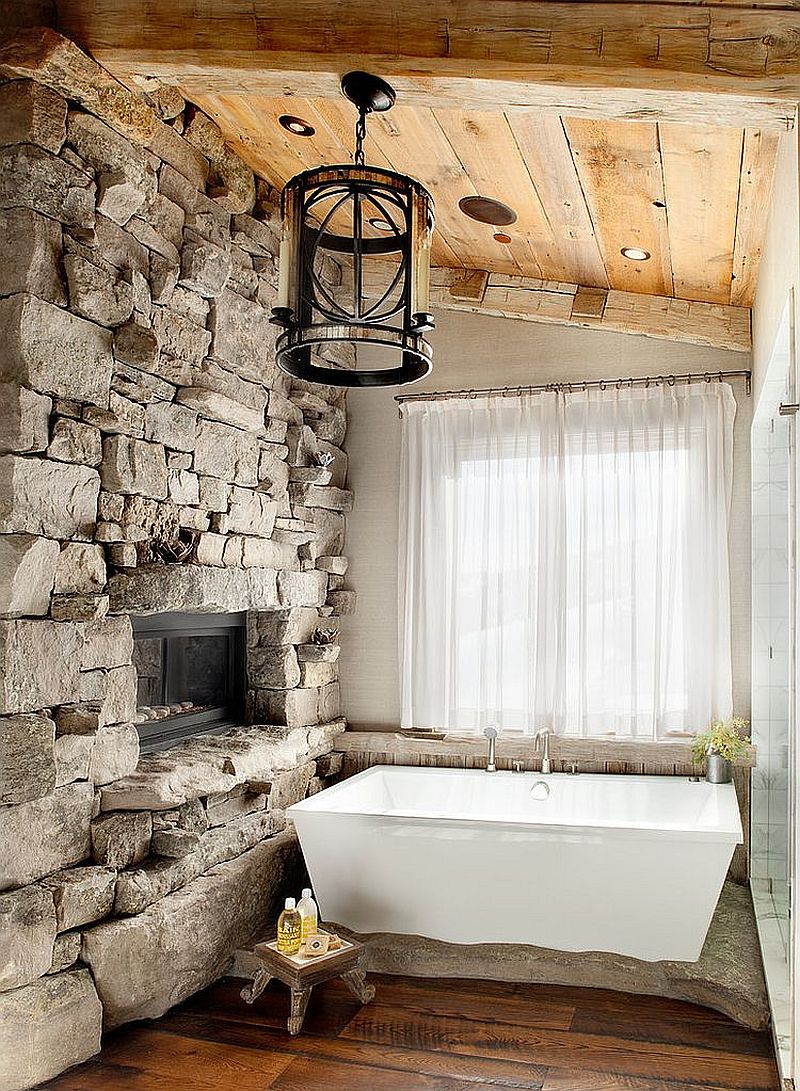 Ski lodge-inspired rustic bathroom with a stone wall and sheer curtains