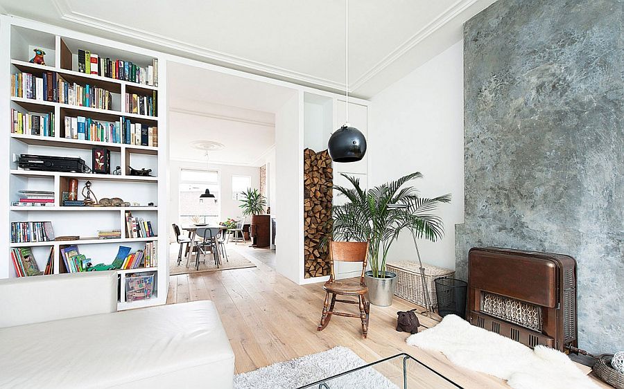 Stacked firewood and concrete fireplace add texture to the living room