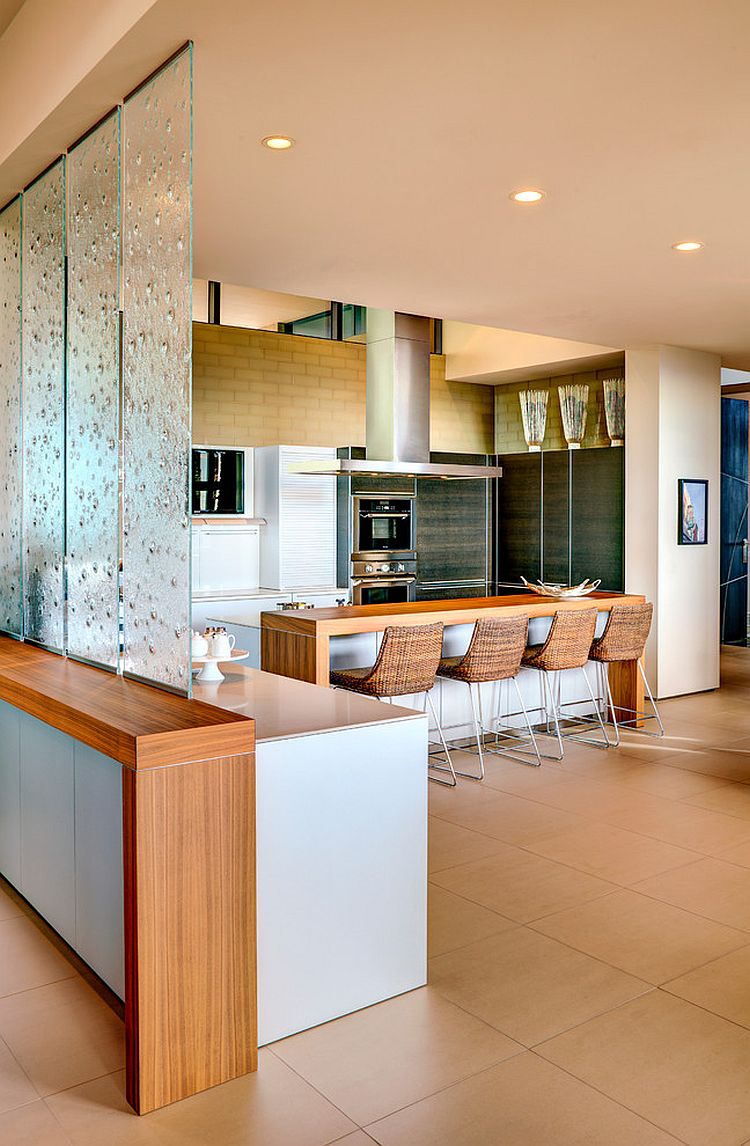 Translucent glass panes create a cool partition between the living area and kitchen