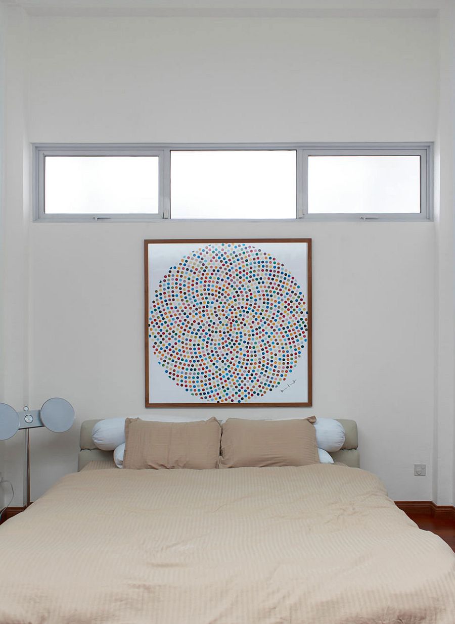 Wall art adds color to the small bedroom in white