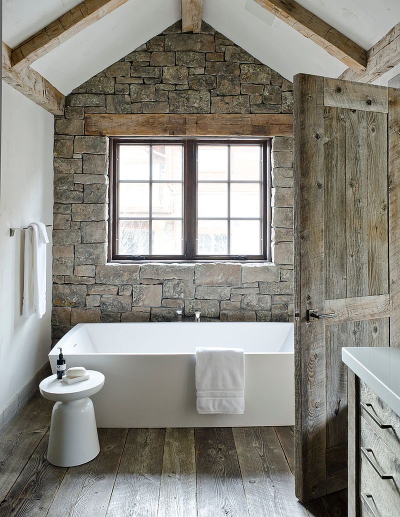 White standalone bathtub with Martini side table and a stone accent wall in the bathroom