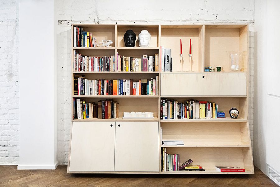 Wooden bookcase set against the exposed brick wall in the open plan living area