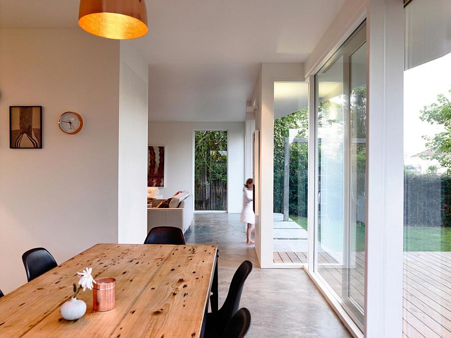 Wooden dining table and black chairs create a room within the kitchen with ease